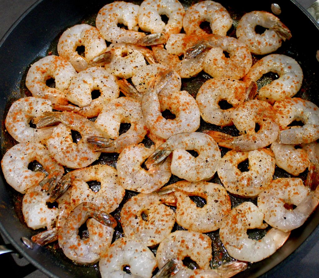 raw shrimp in skillet with smoked paprika on top