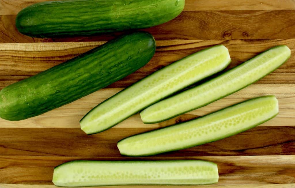 mini cucumbers on cutting board sliced into spears