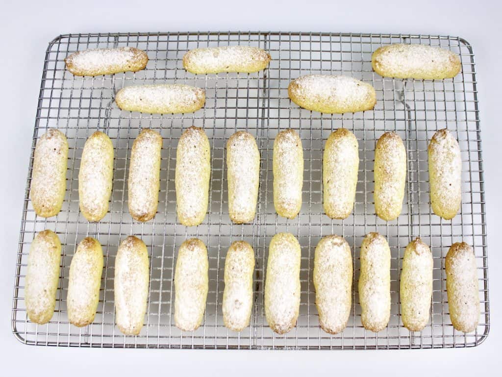 29 lady fingers on wire rack with powdered sugar on top