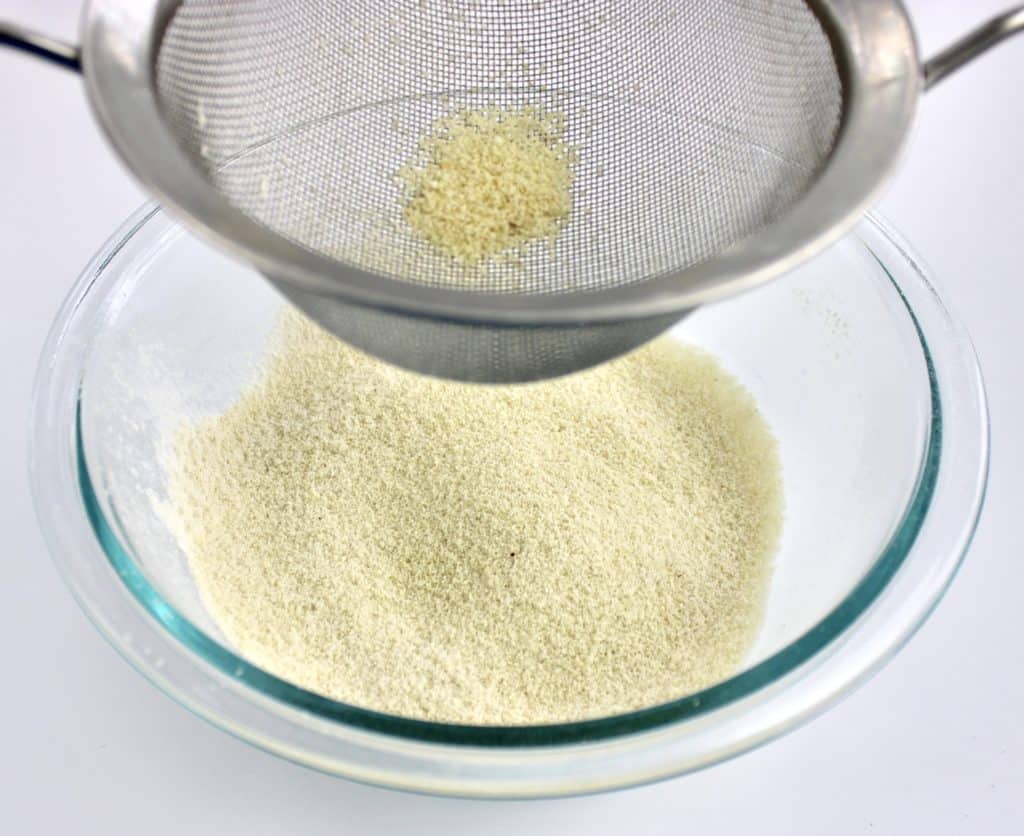 flour being sifted into glass bowl