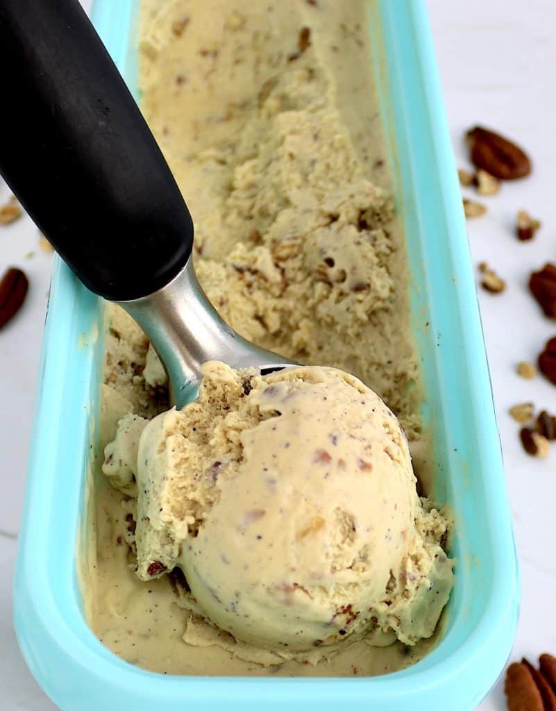 closeup of keto butter pecan ice cream scoop resting in container of ice cream