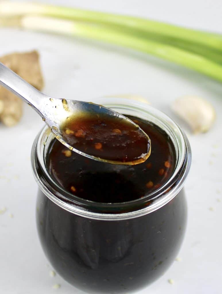 Keto Teriyaki Sauce being spooned out of open glass jar