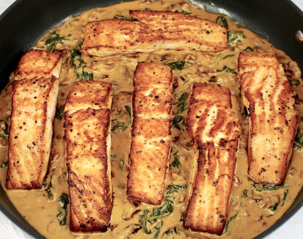 6 pieces of salmon in skillet with tuscan cream sauce