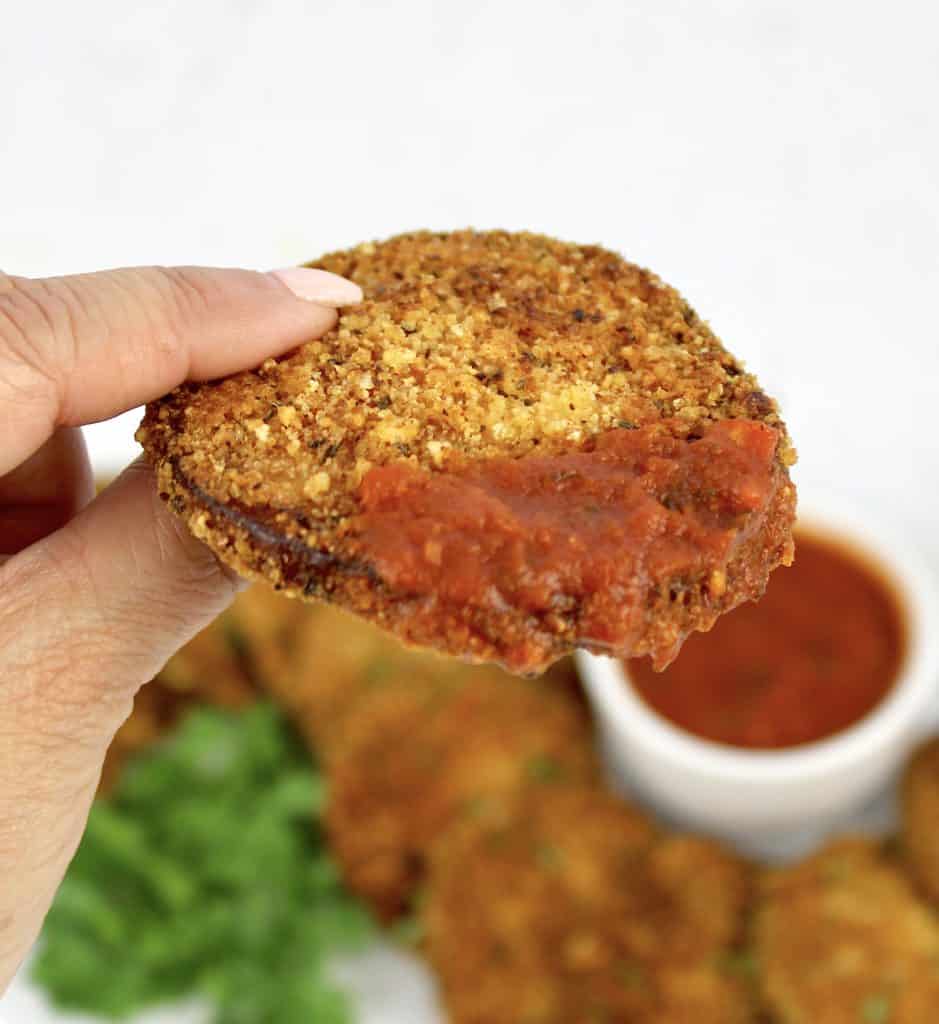 slice of breaded eggplant round that had been dipped in marinara sauce