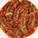 sausage and red and yellow peppers with marinara sauce in bowl