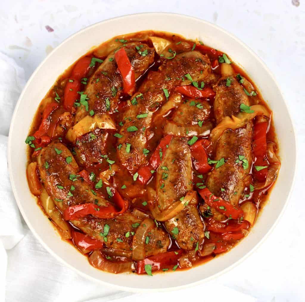 sausage and peppers in marinara sauce in white bowl