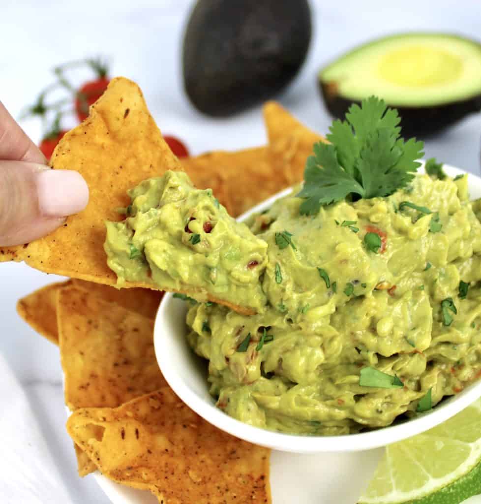 tortilla chip being held up with guacamole