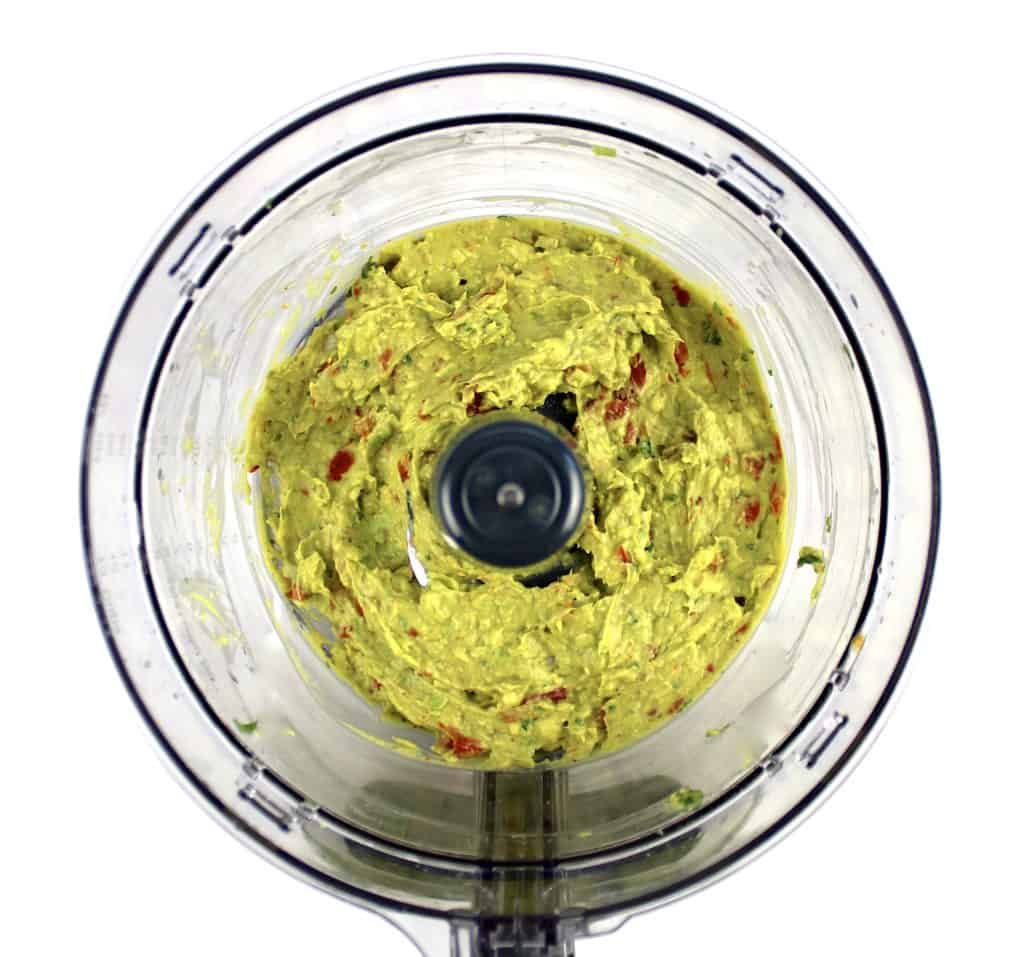 guacamole ingredients in food processor bowl mixed