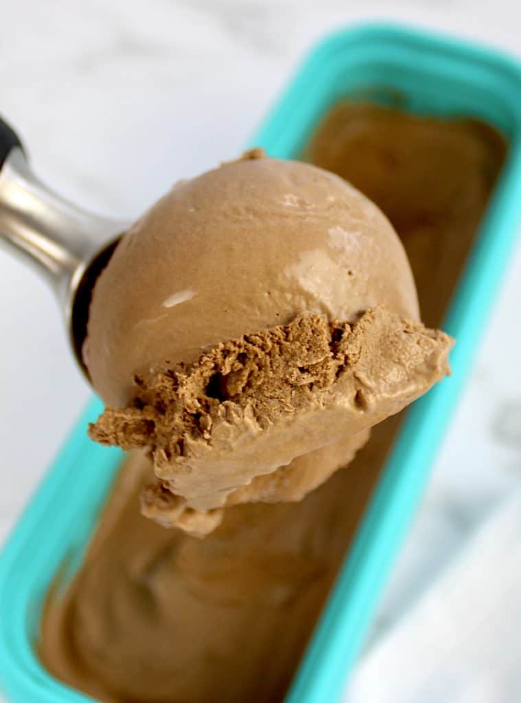 chocolate ice cream scoop held up over container