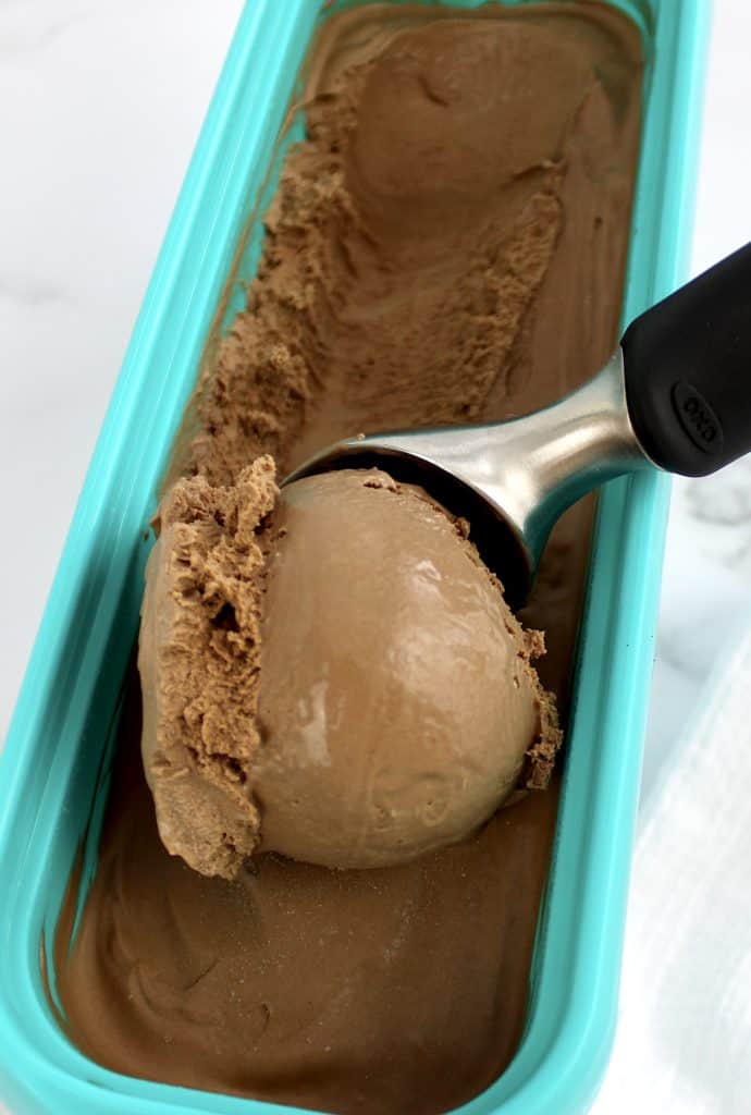 chocolate ice cream in container being scooped out