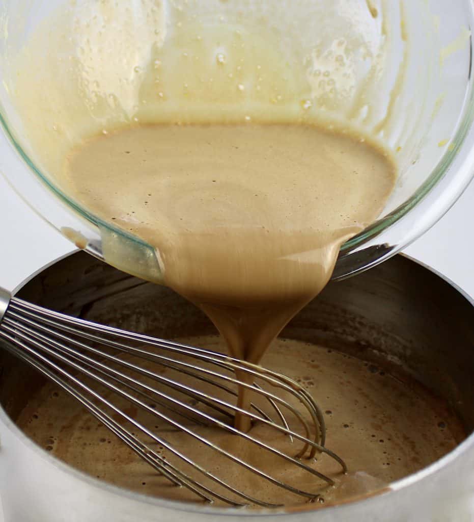 custard being whisked into saucepan