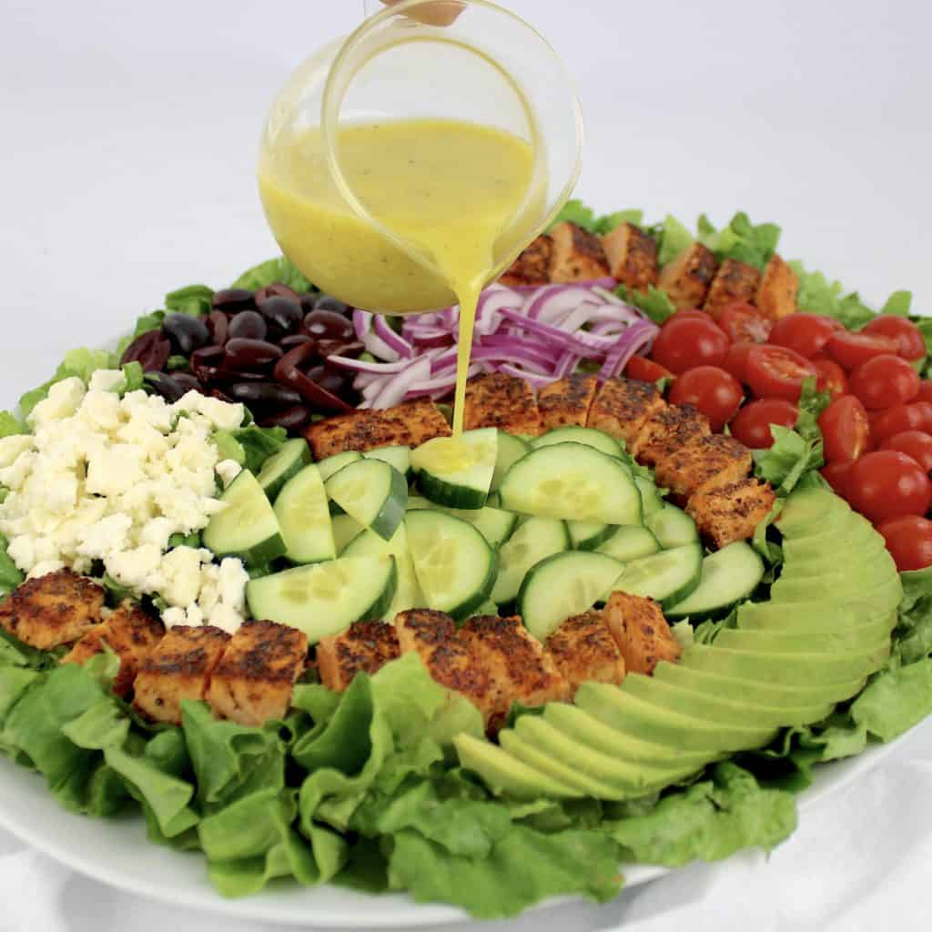 salmon salad with lemon dressing being poured over top