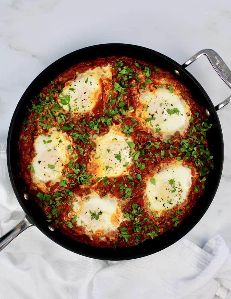Shakshuka with Italian Sausage in skillet with parsley garnish