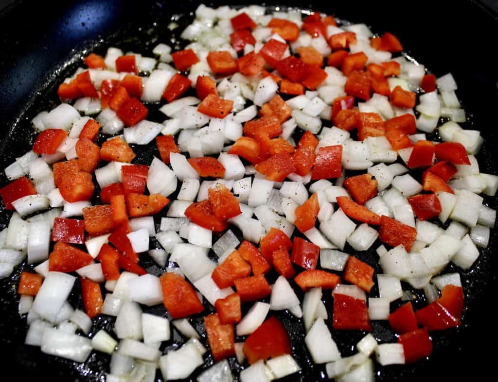 diced red pepper and onions in skillet