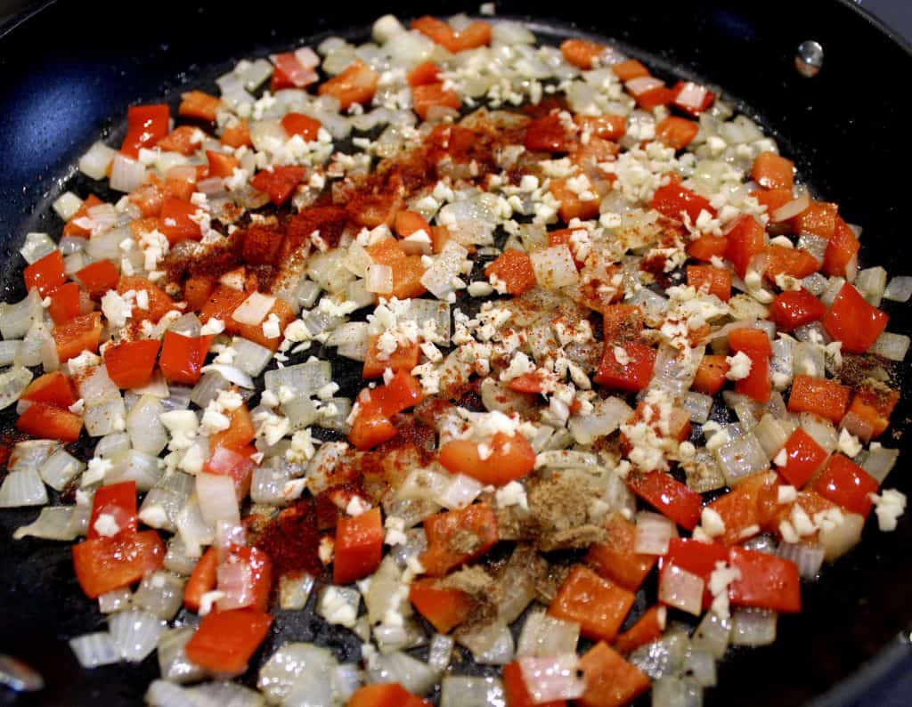 red pepper onions garlic and spices in skillet