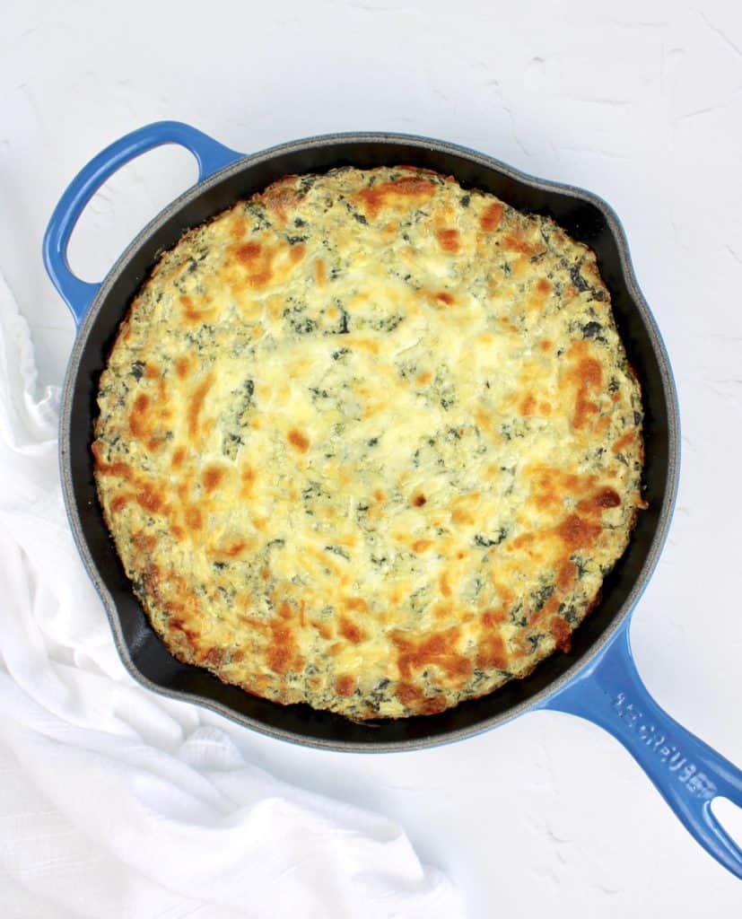 overhead view of Spinach Artichoke Dip baked in cast iron skillet