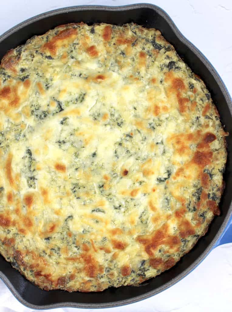 Overhead view of spinach artichoke dip in cast iron skillet