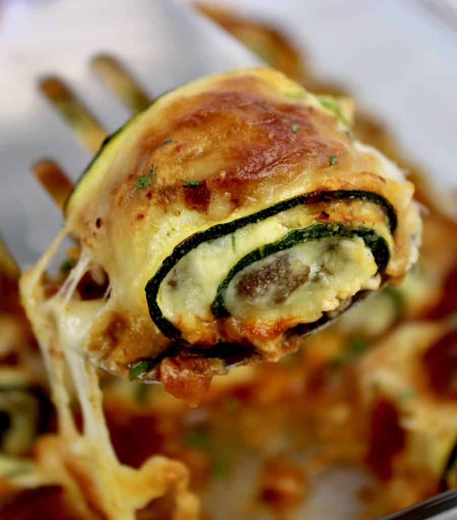 Zucchini Rollatini being held up with spatula out of casserole dish