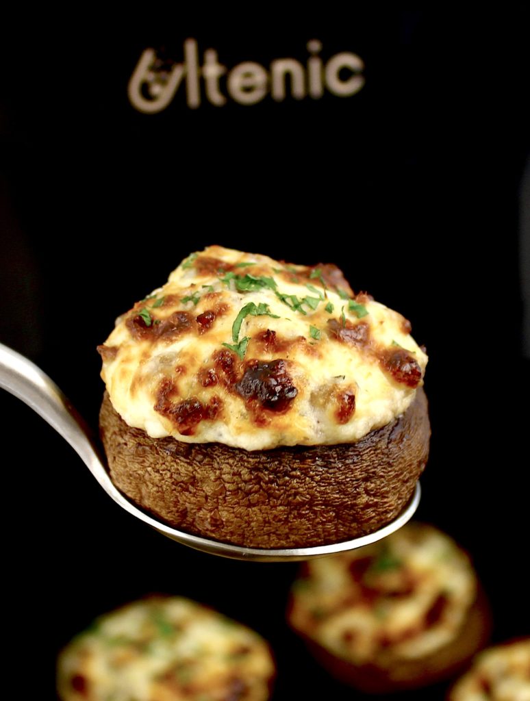 closeup of stuffed mushroom with air fryer in background