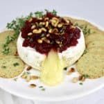 brie with cranberry sauce on top with crackers on side