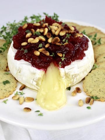 brie with cranberry sauce on top with crackers on side