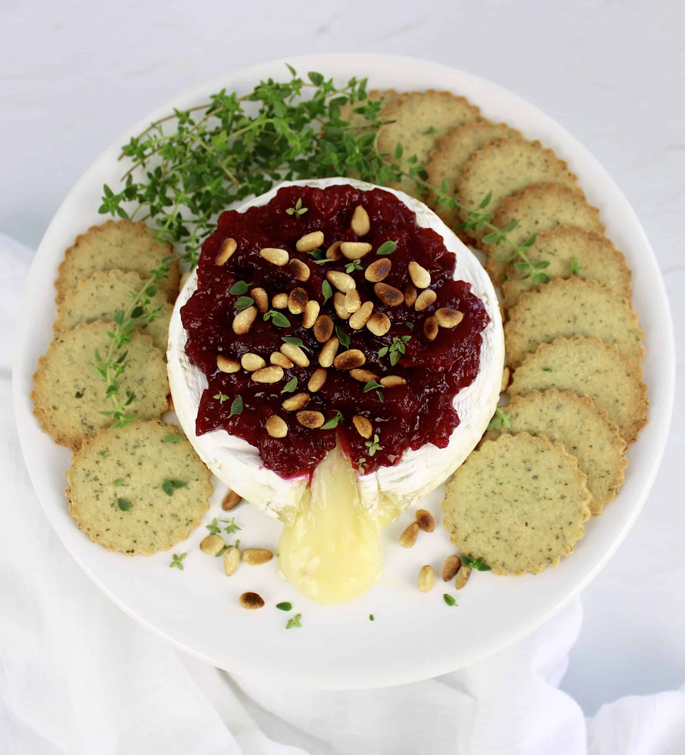 brie with cranberry sauce on top with crackers on side