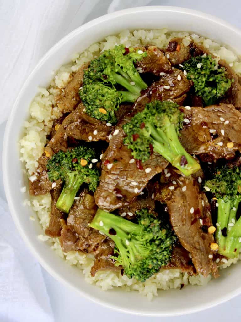 Beef and Broccoli over cauliflower rice in white bowl