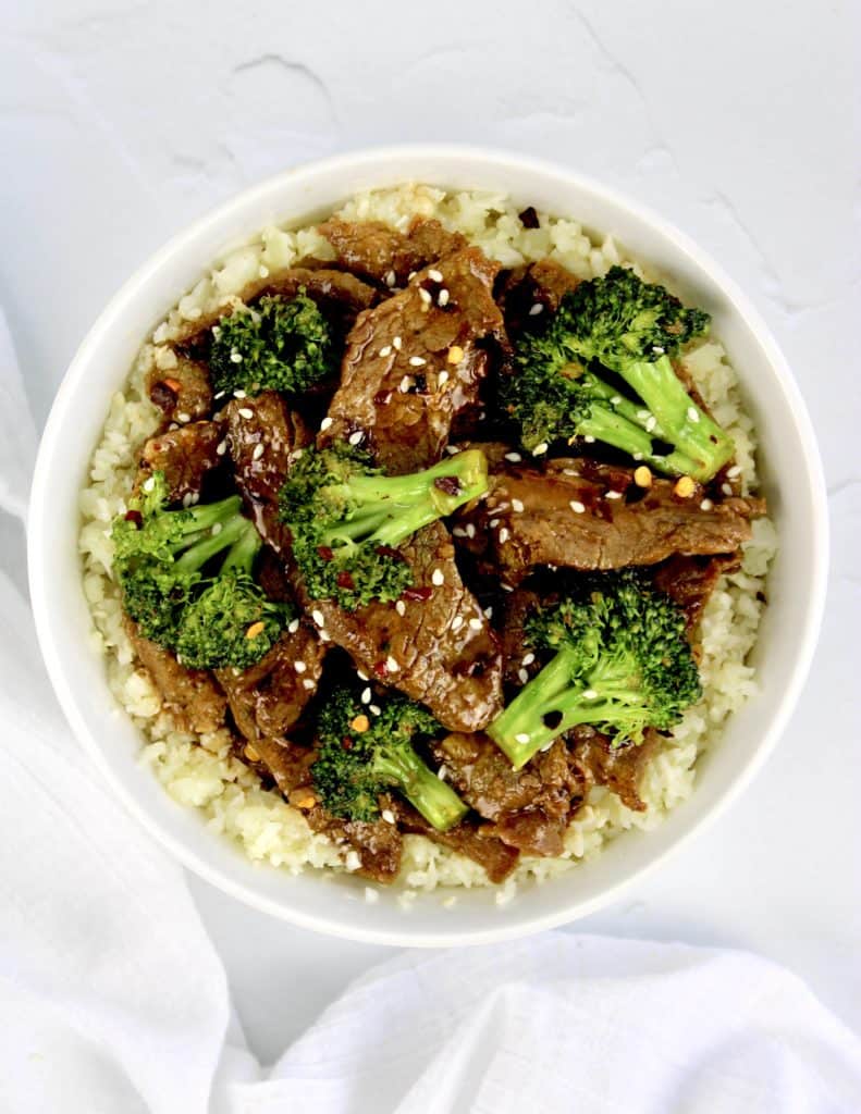 Beef and Broccoli over cauliflower rice in white bowl