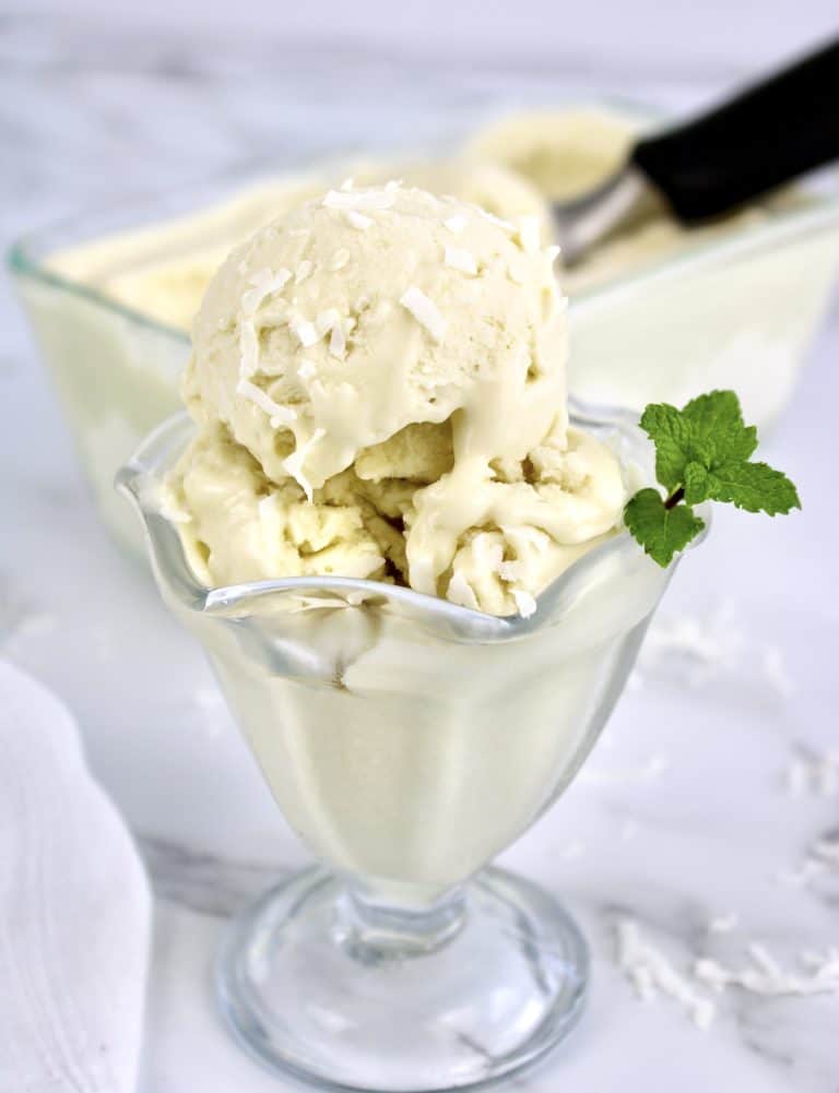 coconut ice cream in glass dish with mint sprig