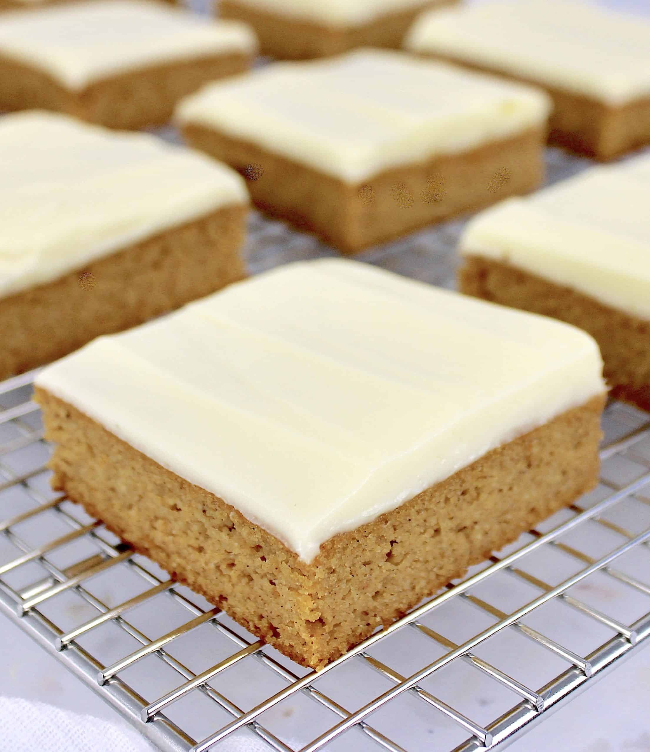 pumpkin bars with frosting on top on wire rack