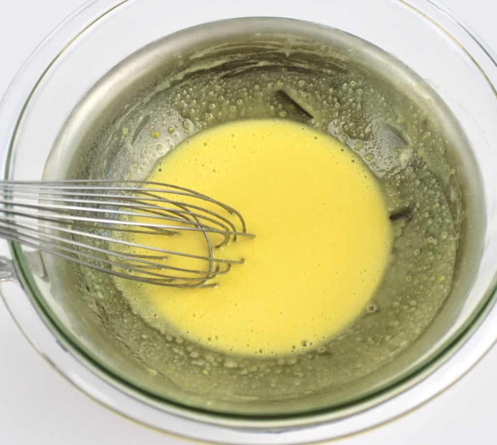 egg yolks and sugar being whisked over double boiler