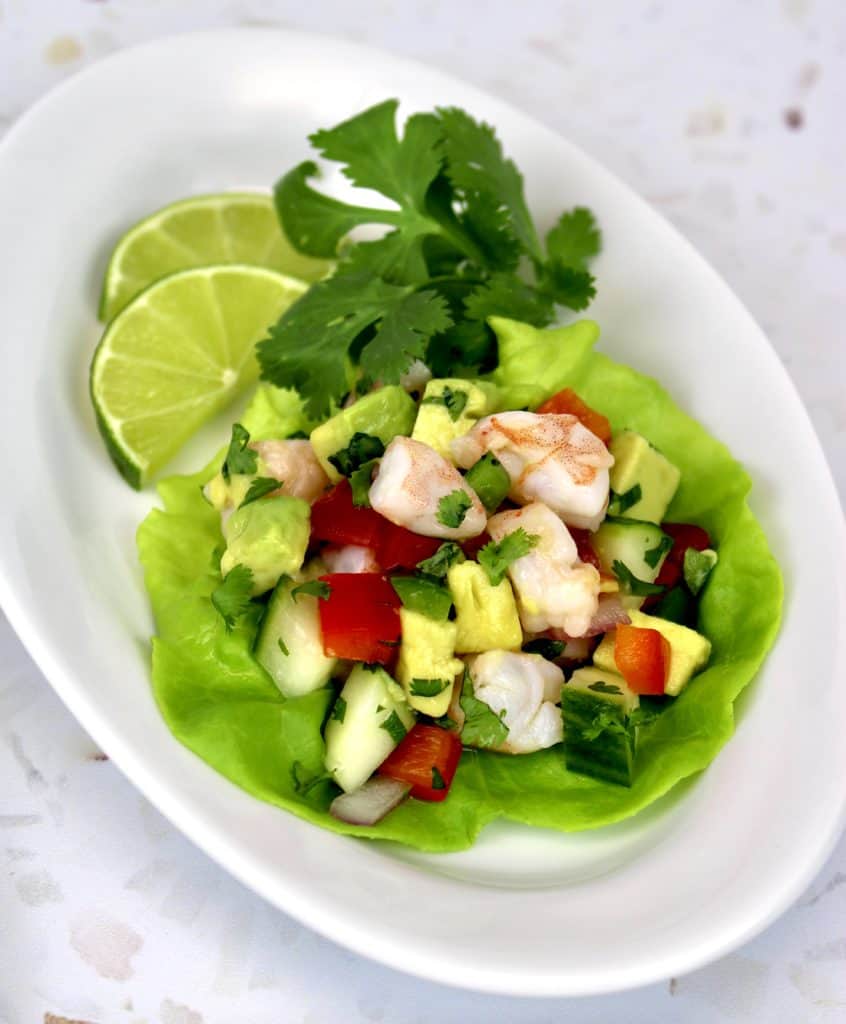Shrimp Ceviche in lettuce cup with cilantro and lime slices on side