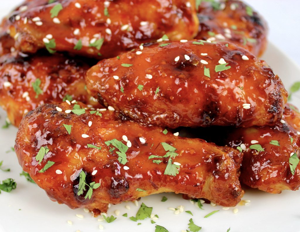 side view closeup of Sticky Asian Chicken Wings on white plate