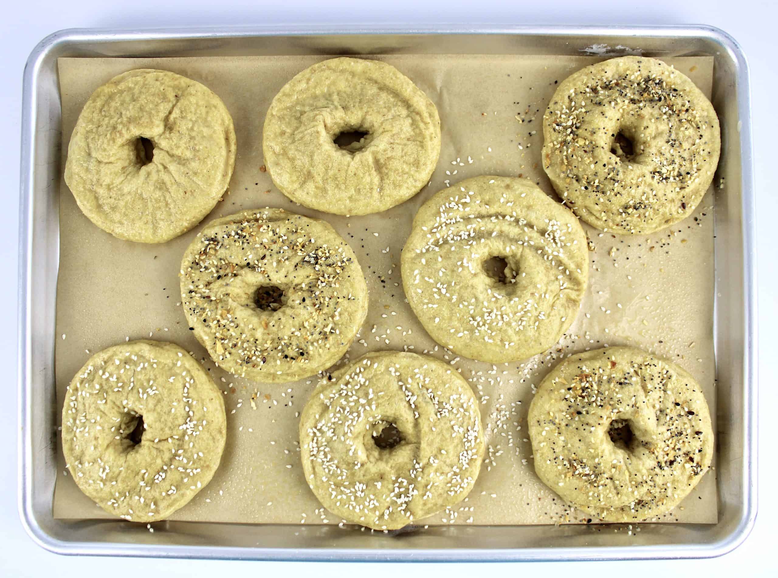 8 bagels unbaked on parchment lined baking sheet