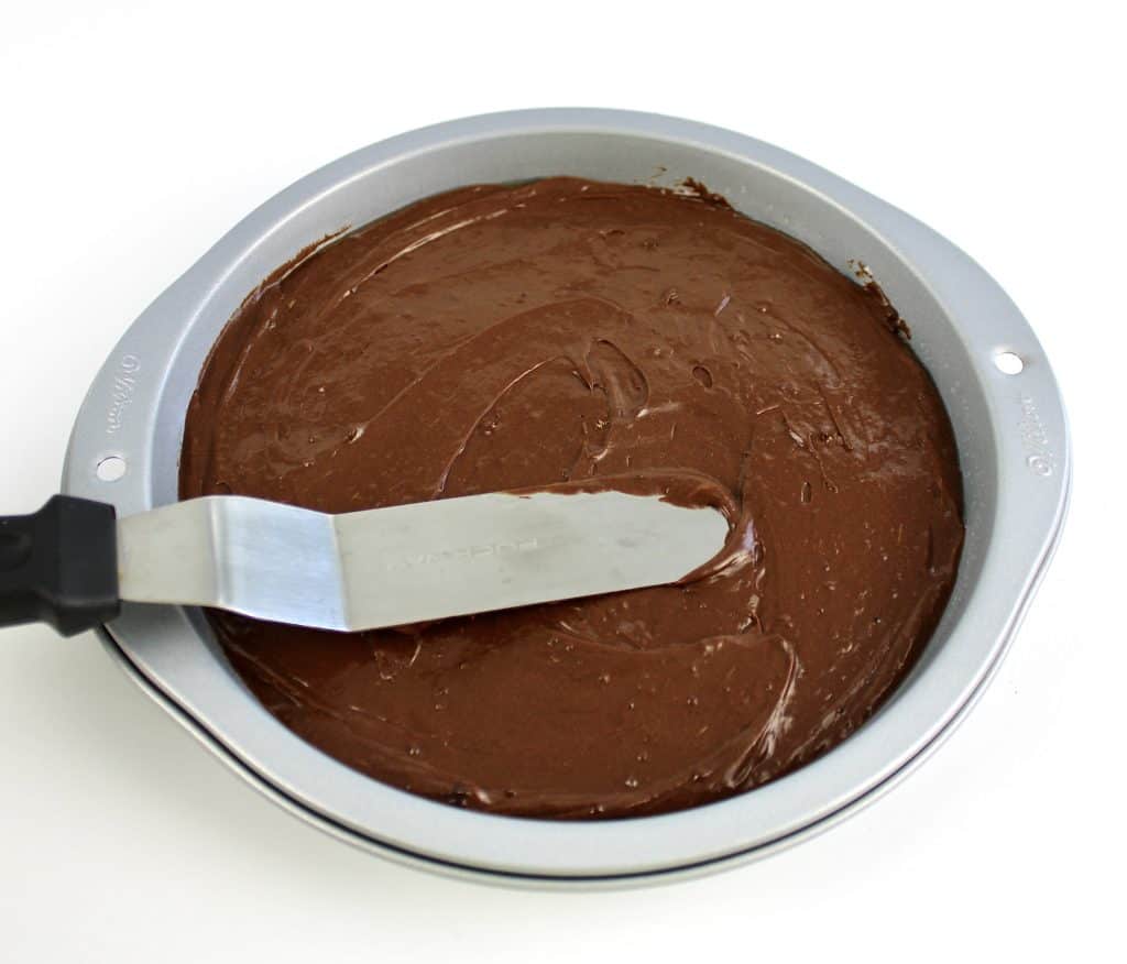 chocolate cake batter being spread with offset spatula