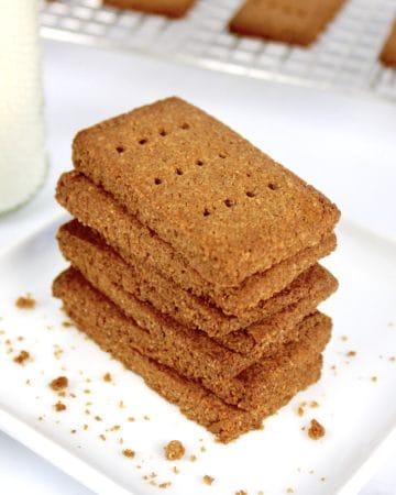 stack of graham crackers on white plate with milk bottle on side