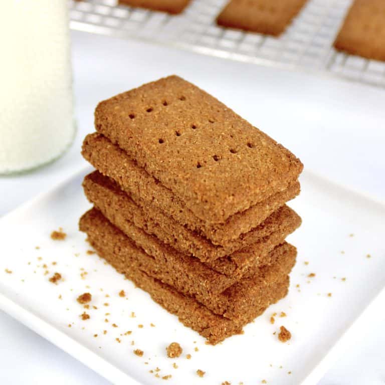 stack of graham crackers on white plate with milk bottle on side