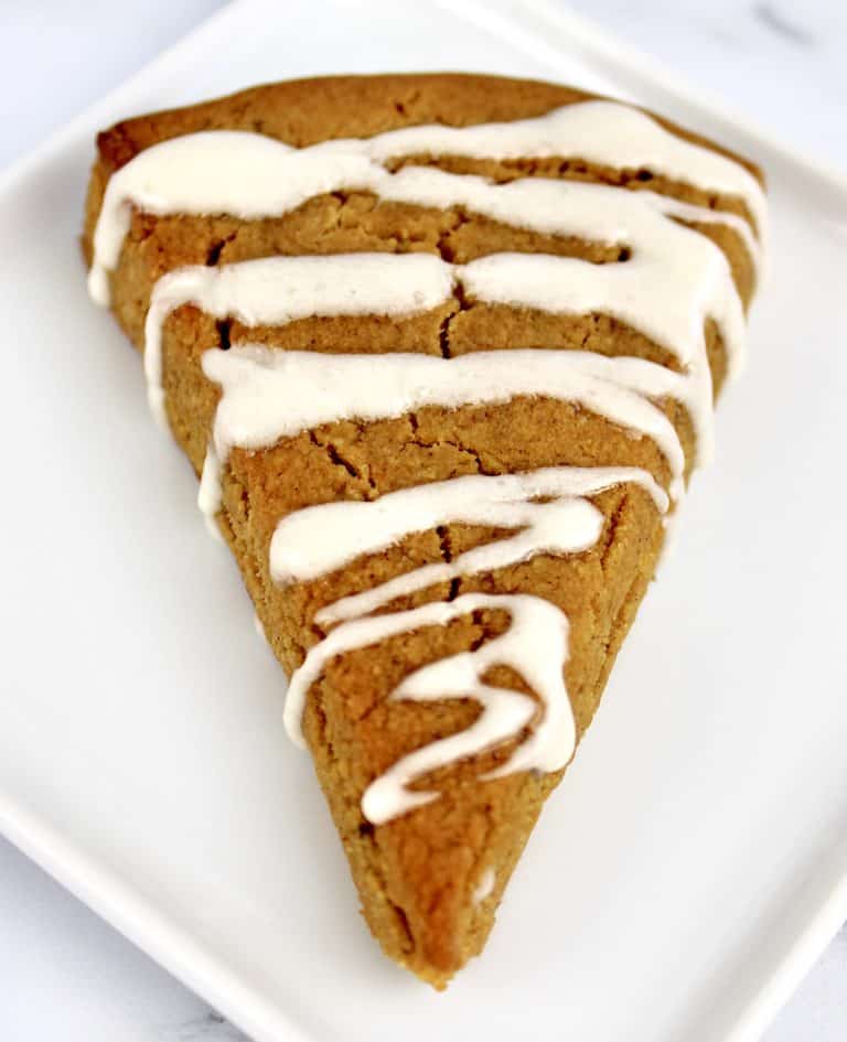 overhead view of pumpkin scone on cooling rack with icing drizzle on top