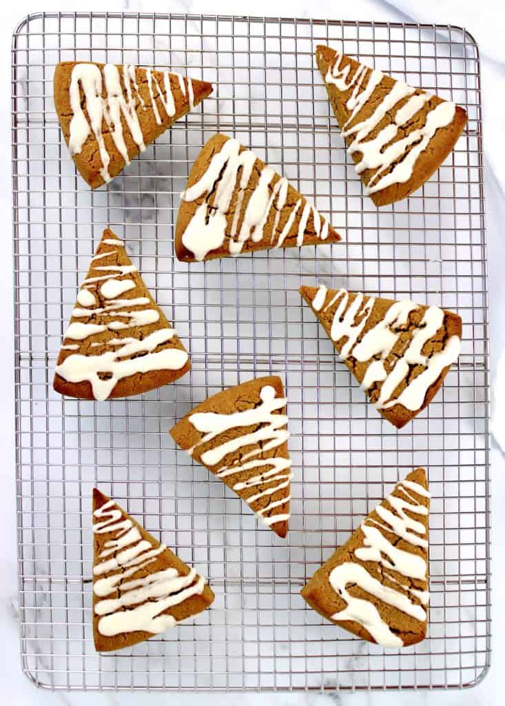 8 pumpkin scones on cooling rack with icing zigzag on the tops