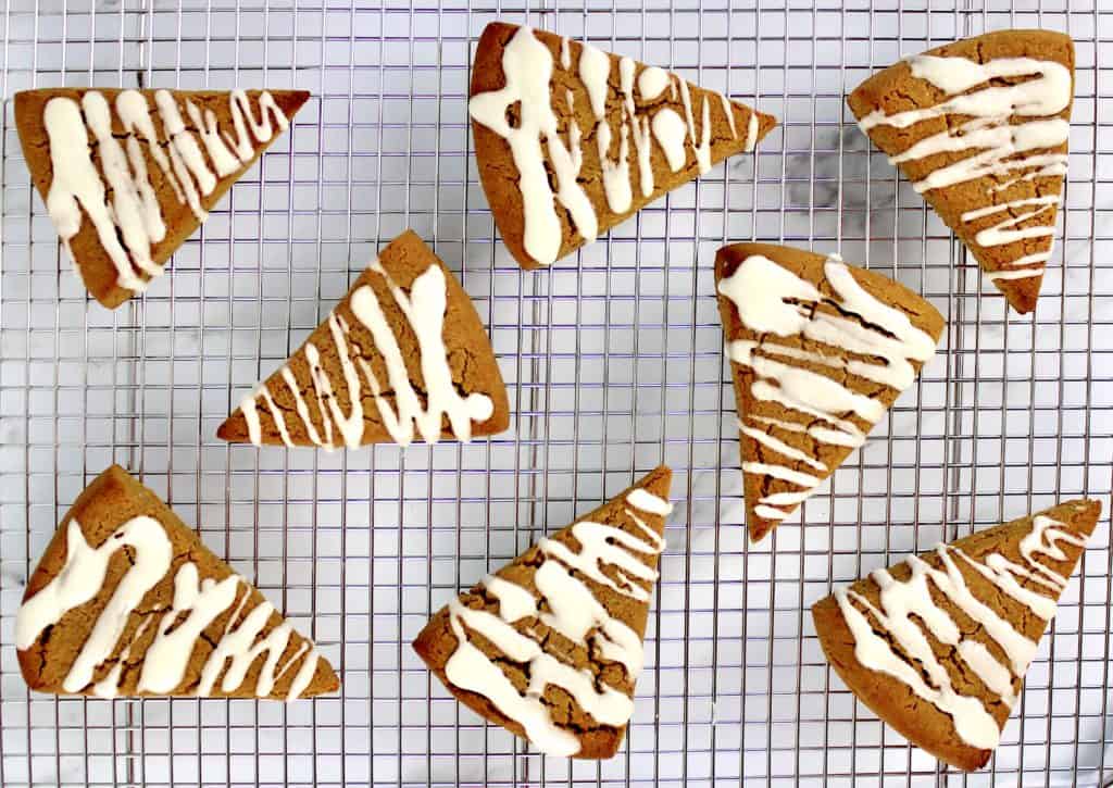 pumpkin scones on cooling rack with icing zigzag on the tops