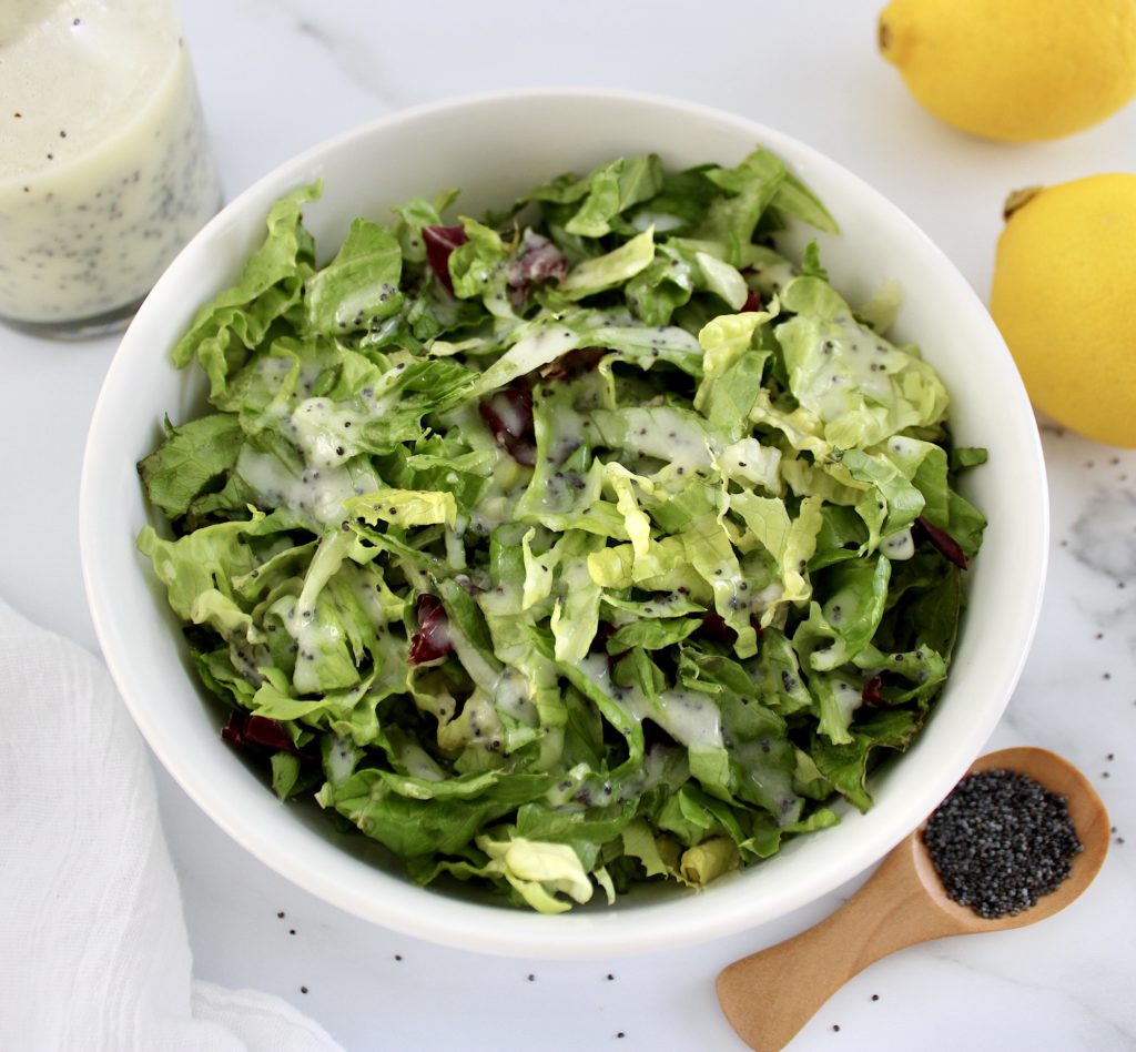 salad in white bowl with lemon poppy dressing 