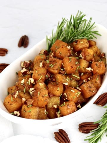 Maple Roasted Butternut Squash in white bowl with rosemary garnish