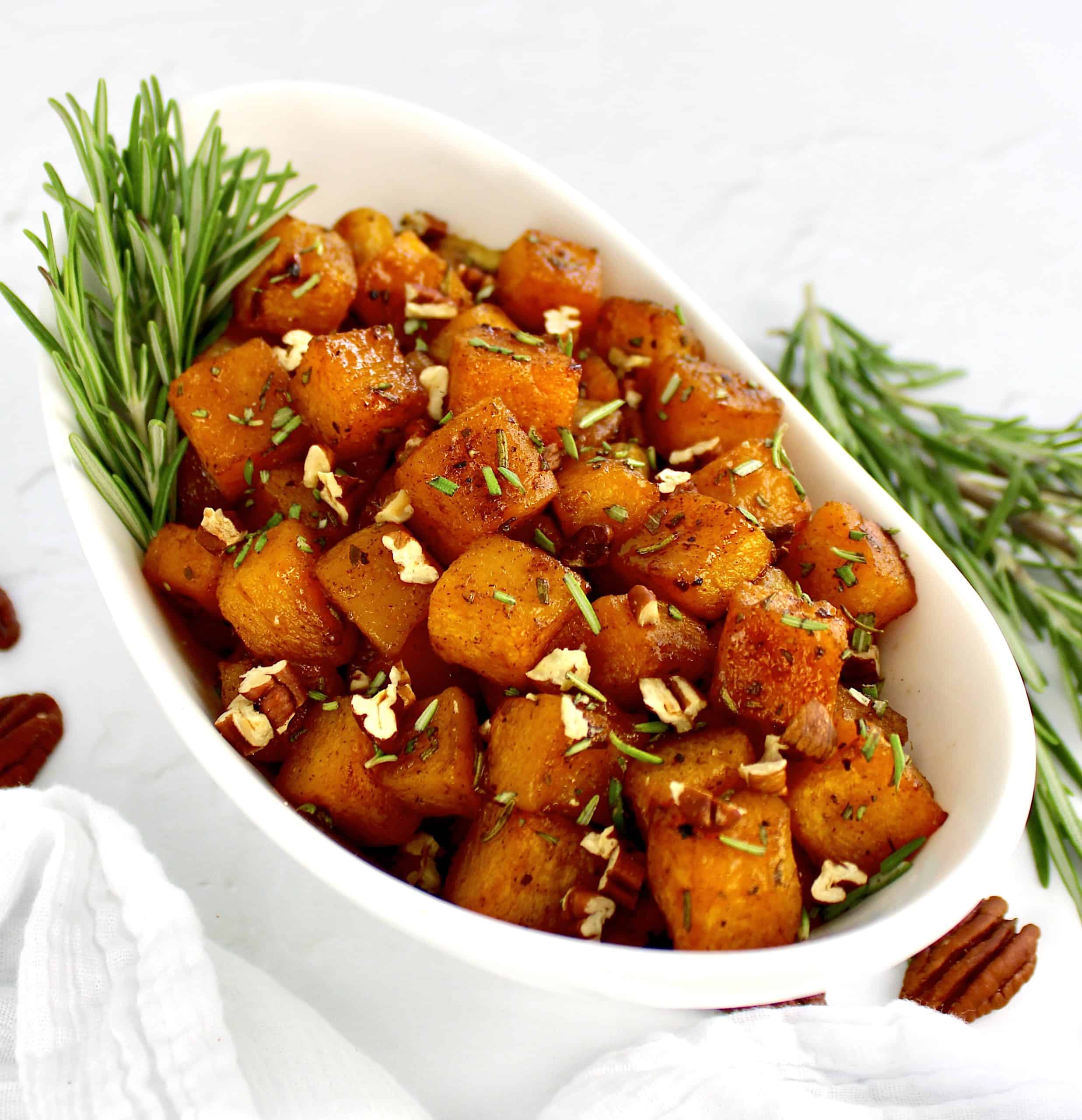 Maple Roasted Butternut Squash in white bowl with rosemary garnish