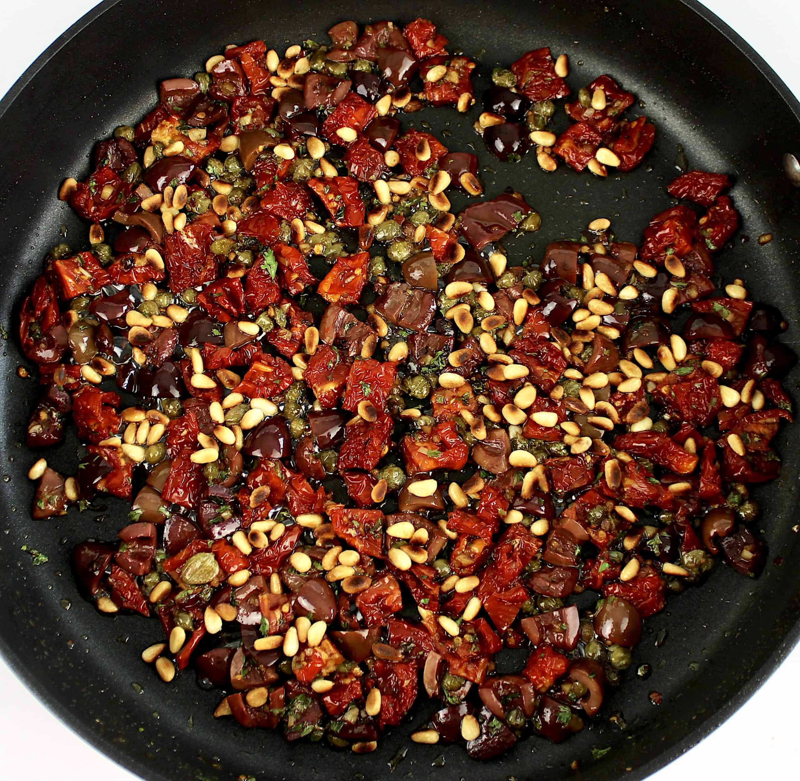 chopped olives sun-dried tomatoes pine nuts and capers in skillet