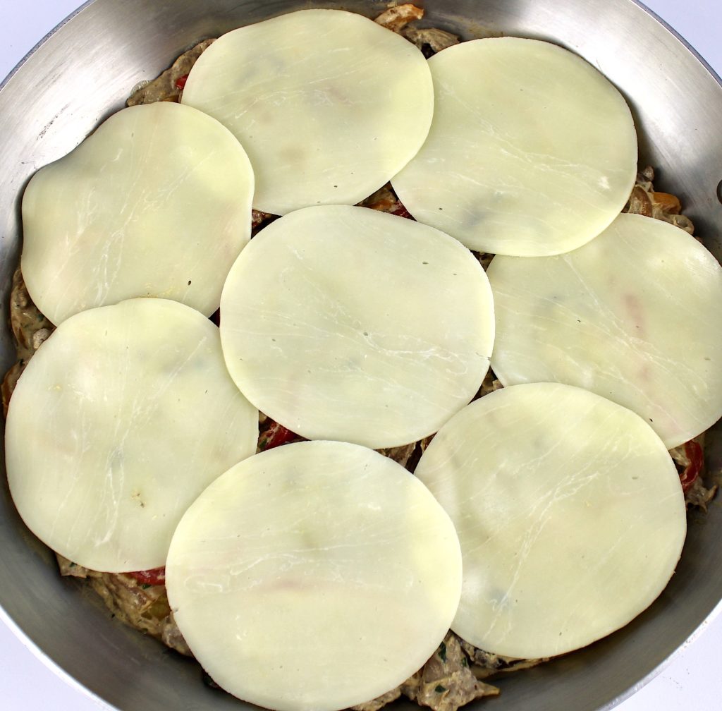 skillet with 8 slices of provolone cheese on top in a circle