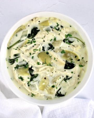 bowl of spinach artichoke chicken soup with parsley garnish