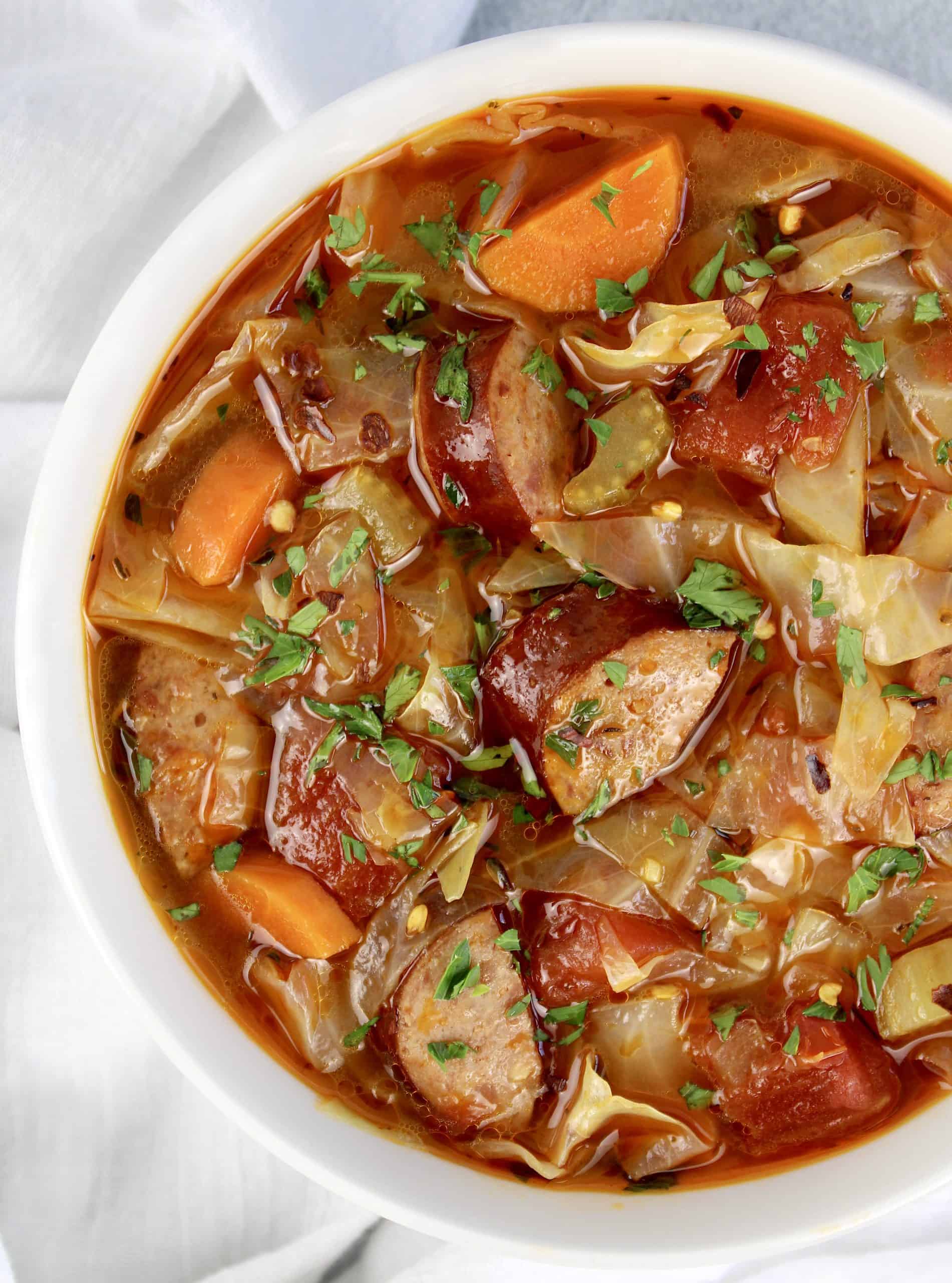 overhead view of Cabbage Soup with Sausage in white bowl