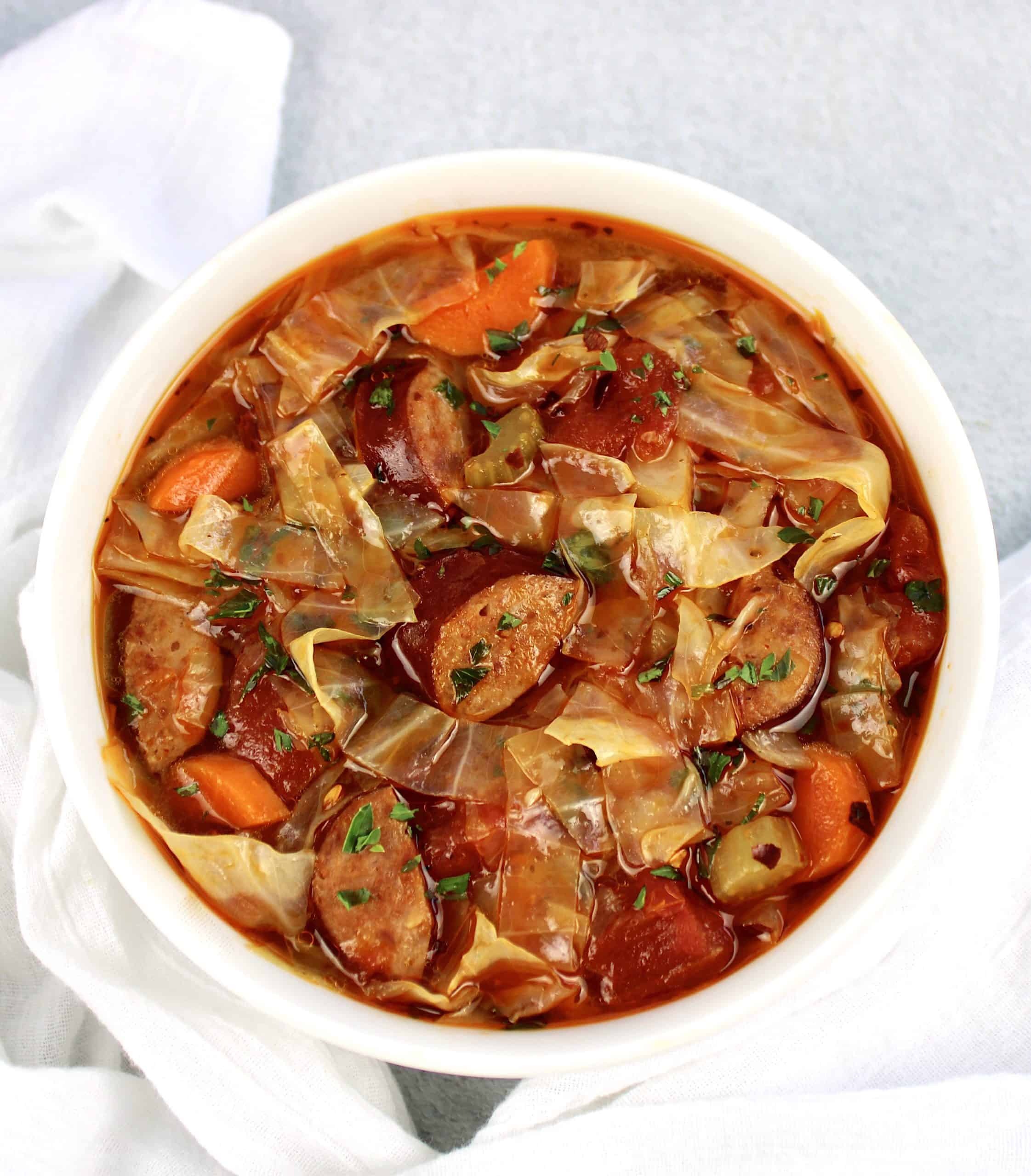 bowl of Cabbage Soup with Sausage carrots in white bowl