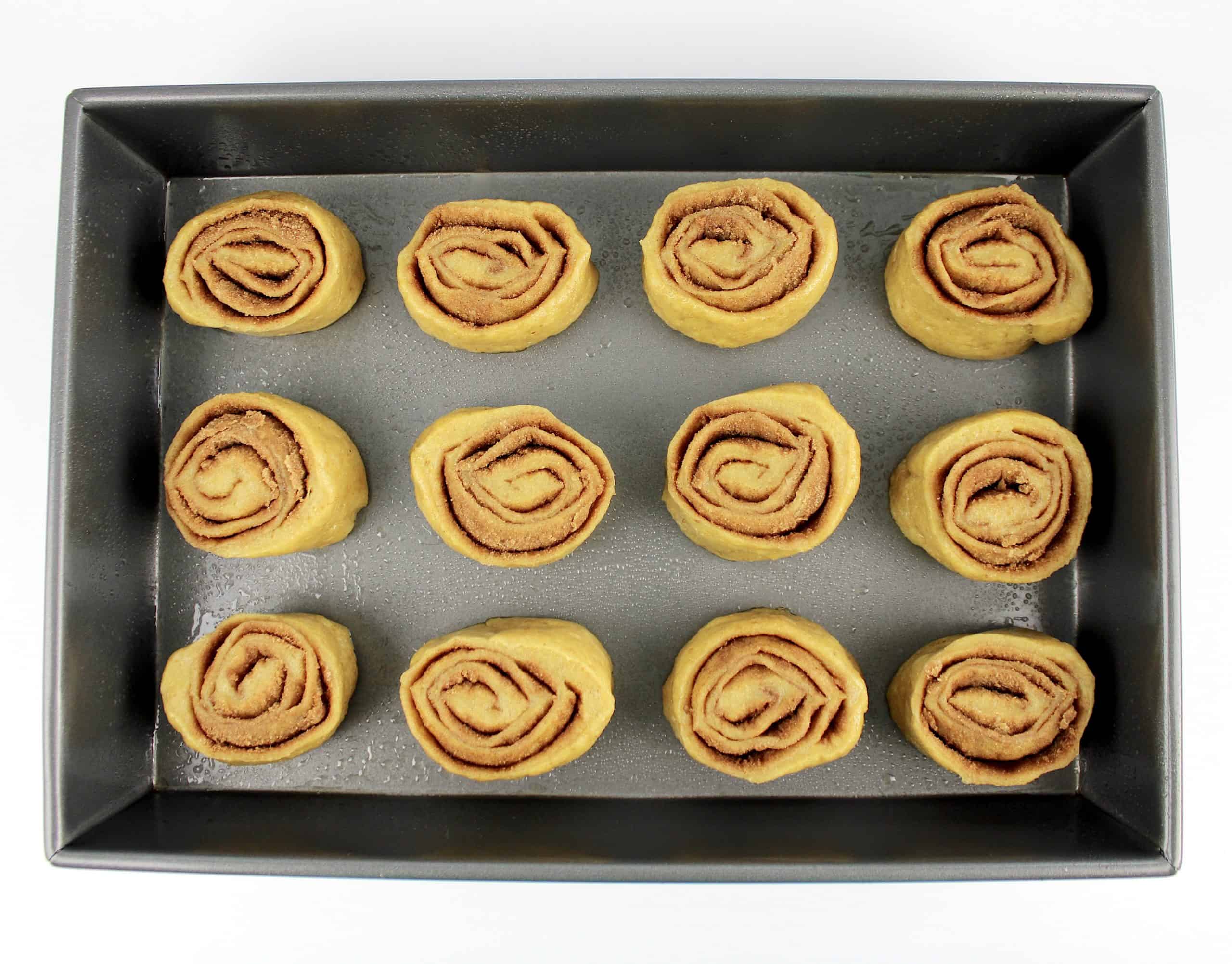 12 raw cinnamon roll dough in baking pan