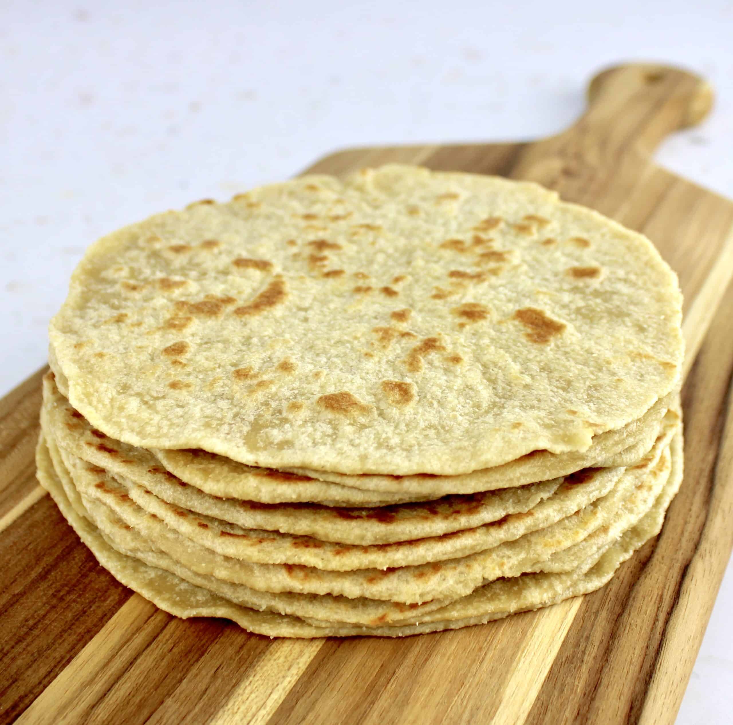 keto tortillas stacked up on cutting board